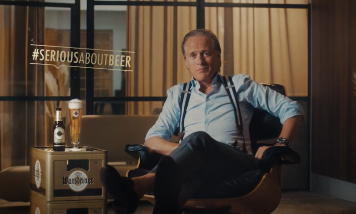 Jort Kelder zit naast een krat Warsteiner waar een flesje en een gevuld glas bier bovenop staat
